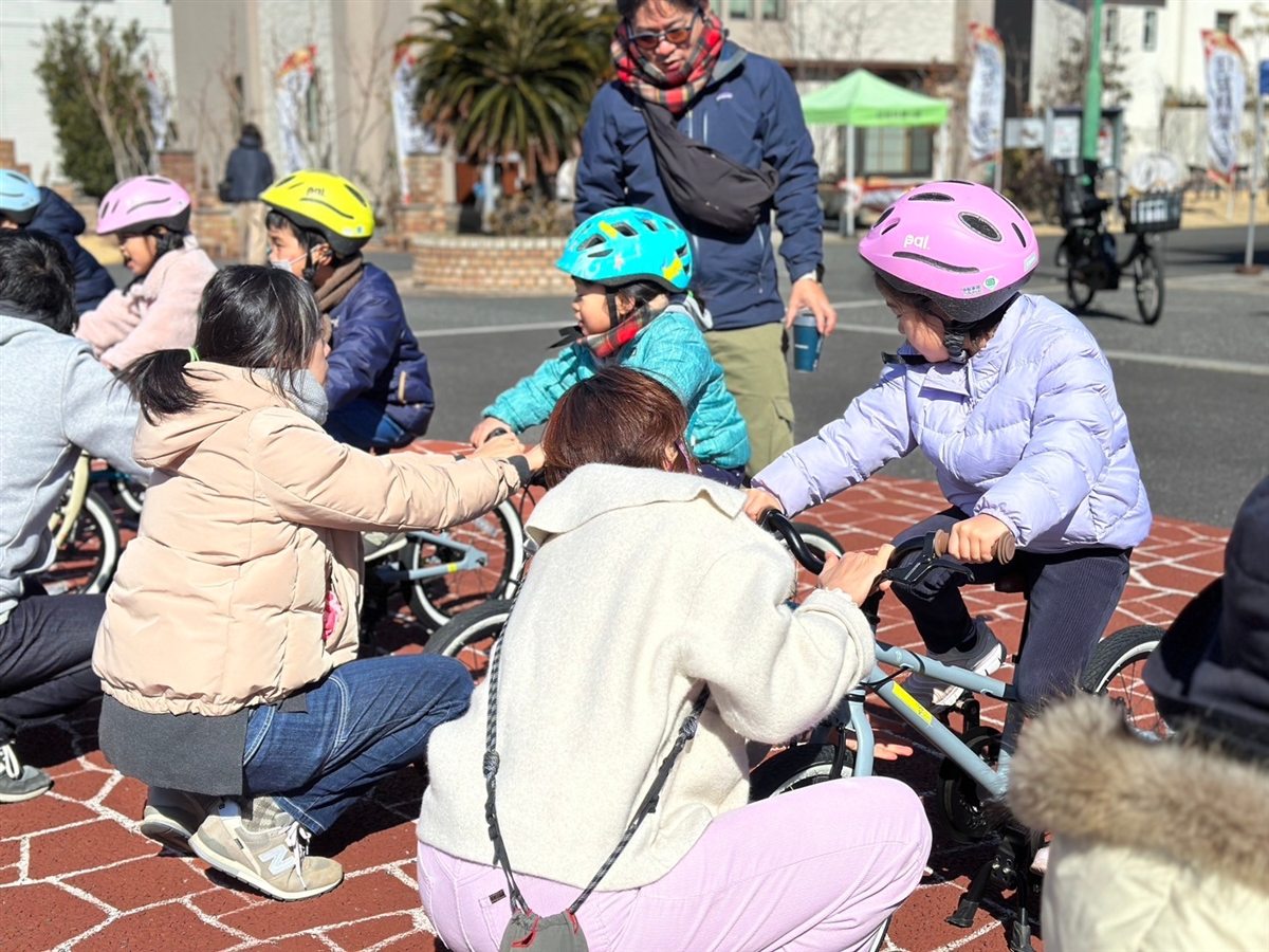 保護者がお子さまの自転車を支えながら一緒に練習する様子